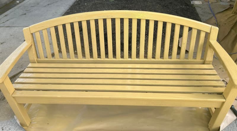 Garden bench after — freshly painted smooth golden finish
